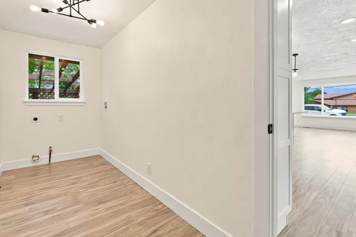 Wood-finish flooring, white trim, and a modern light fixture
