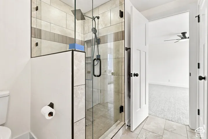 Master Bath - Glass-enclosed shower with a rainfall showerhead, integrated shower niche, and tiled walls