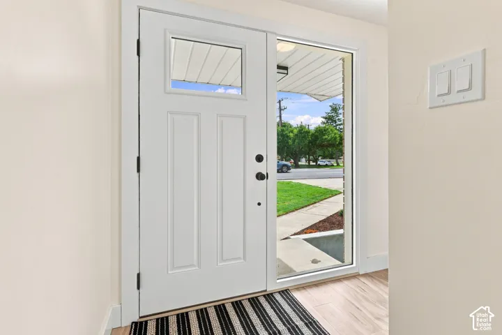 White panel door with a clear glass upper panel, paired with a full-length clear glass sidelight