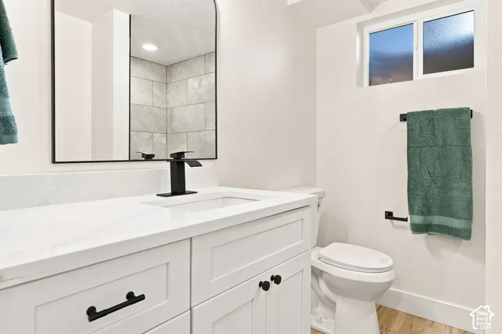White vanity with shaker-style cabinetry, a built-in sink, and a black single-handle faucet