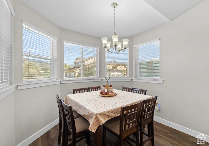 Bay window with multiple windows, wood-finish flooring, and a multi-arm chandelier