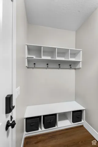 Built-in storage bench with cubbies, upper shelving, and integrated coat hooks