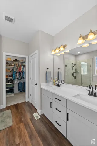 Dual vanity with white countertops, matte black fixtures, and light grey cabinetry