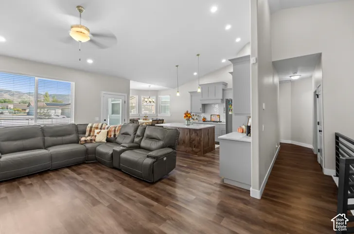 Vaulted ceilings, recessed lighting, wood-finish flooring, kitchen island, and contemporary cabinetry