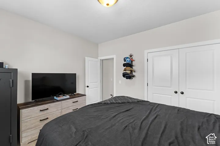 Neutral wall color, wood-finish flooring, ceiling-mounted light fixture, white interior doors, and black door hardware