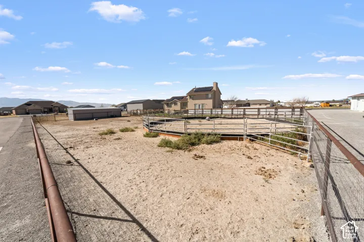 Expansive land parcel featuring an equestrian arena with metal fencing and a gravel driveway