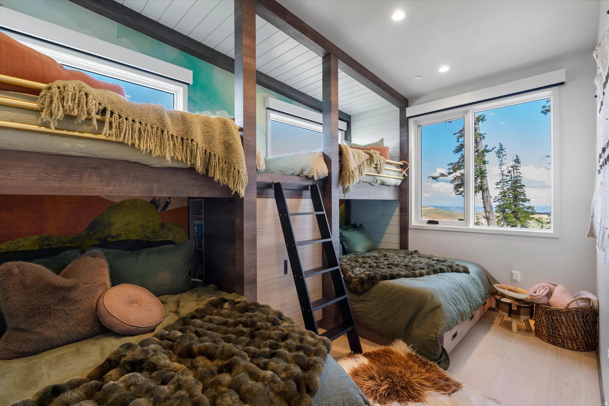 Built-in bunk beds with integrated storage, wood-finish flooring, recessed lighting, and expansive windows