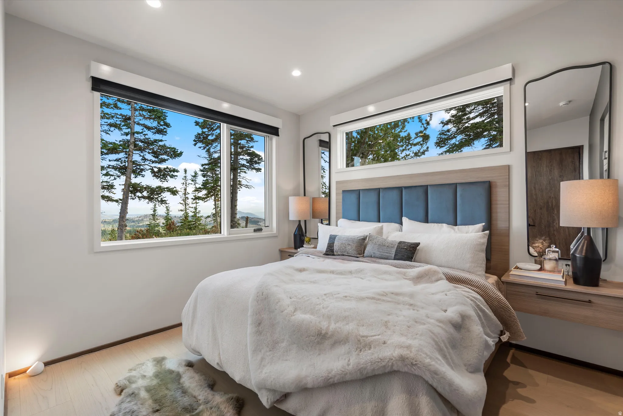 Expansive windows featuring a natural outdoor setting and recessed lighting