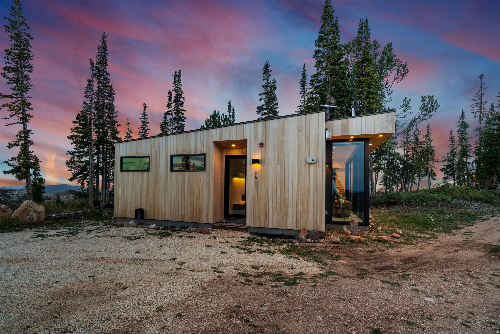 Modern exterior featuring wood-finish siding, a sloped roofline, and integrated outdoor lighting