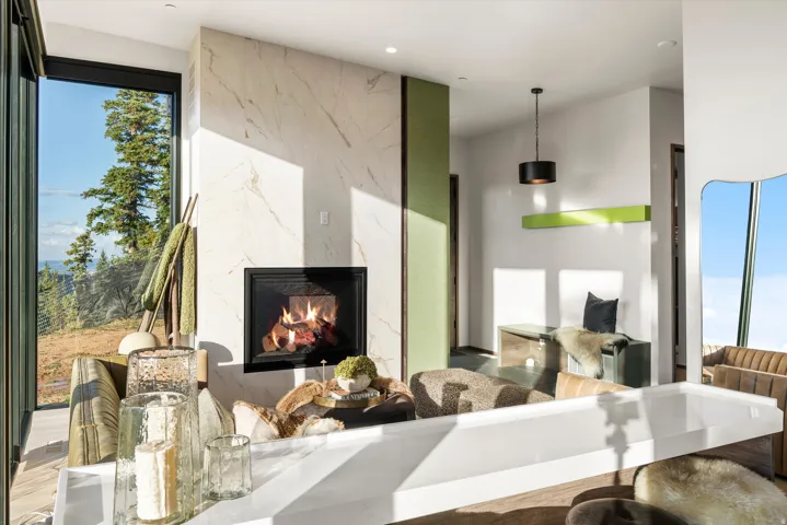 Floor-to-ceiling window, natural stone fireplace, recessed lighting, wood-finish flooring, and a contemporary wall panel