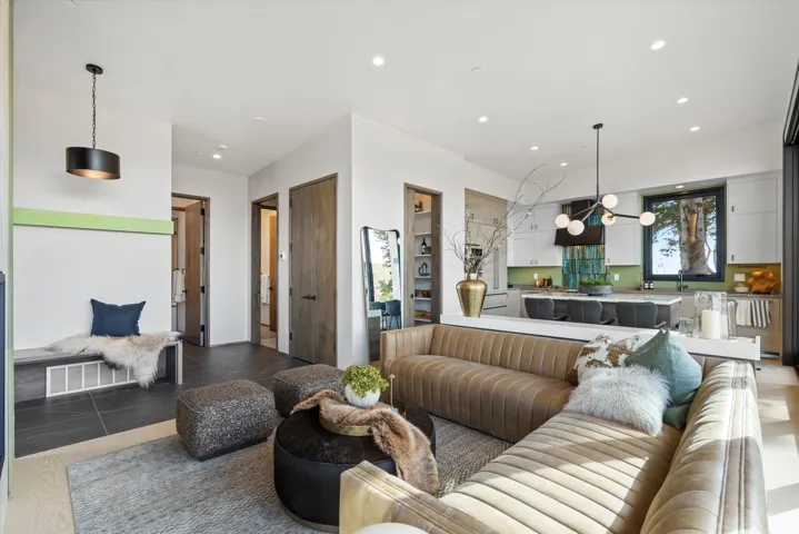 Open-concept living space featuring light wood-finish flooring, recessed lighting, and a contemporary pendant fixture
