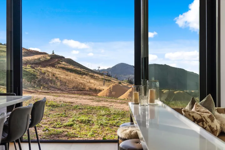 Floor-to-ceiling windows, mountain scenery, full-length glass panels, and a polished counter surface