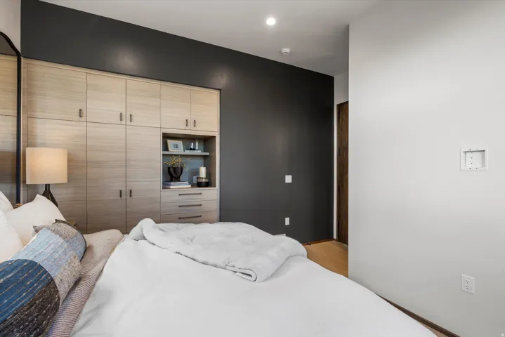 Built-in cabinetry with integrated shelving and drawers, recessed ceiling lighting, and a dark accent wall