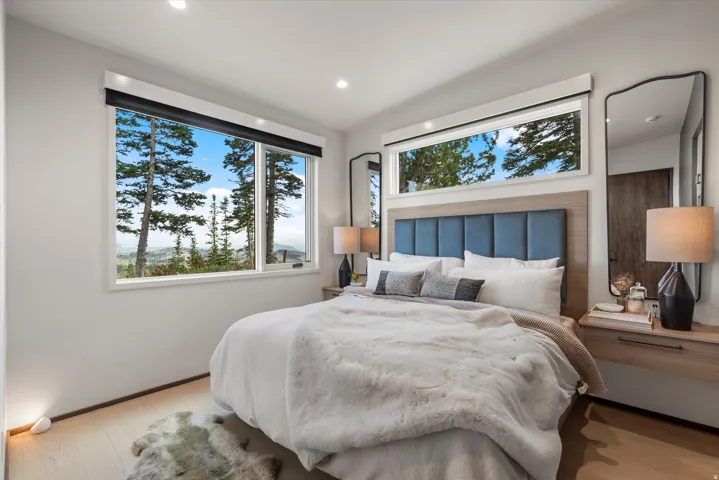 Expansive windows featuring a natural outdoor setting and recessed lighting