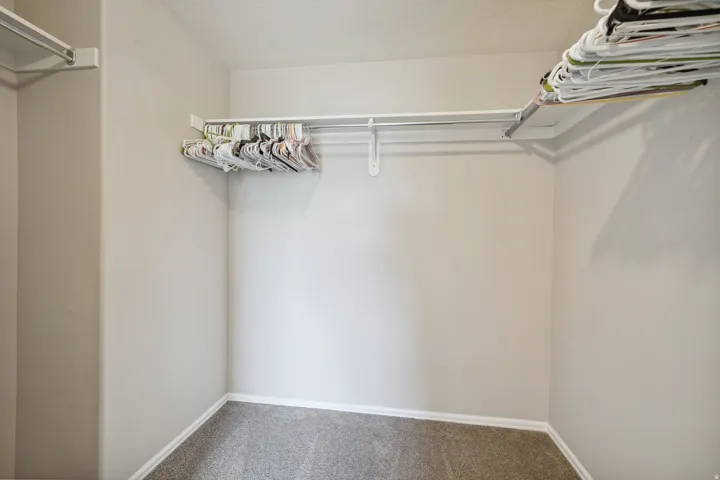Recessed wall space with wall-mounted shelving and clothing rods