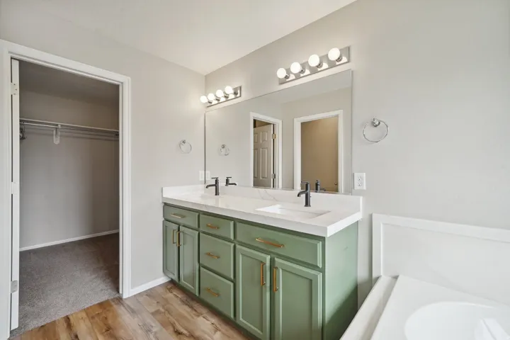 Dual vanity with white countertops, integrated sinks, and black fixtures