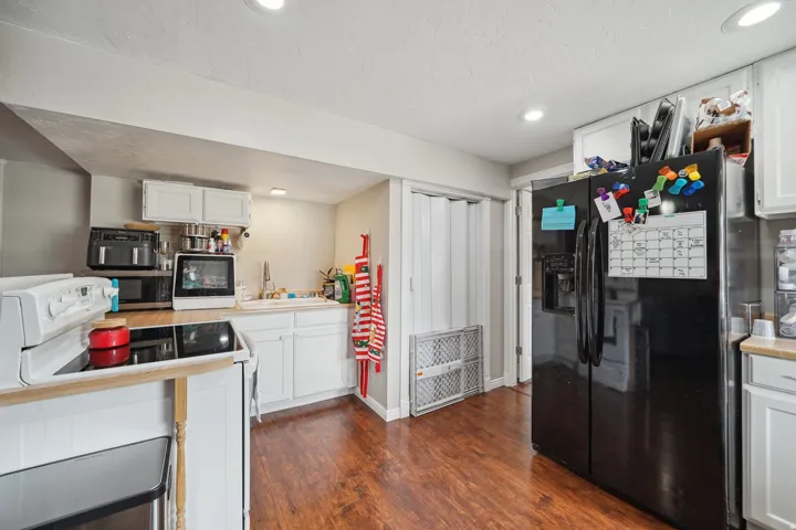 Kitchen featuring wood-finish flooring, white cabinetry, a white electric range, and recessed lighting