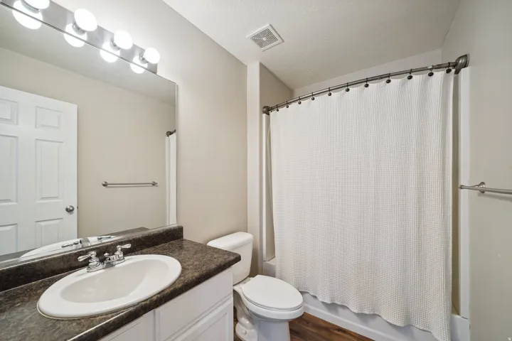 Vanity with an integrated sink, polished chrome faucet, and expansive wall-mounted mirror