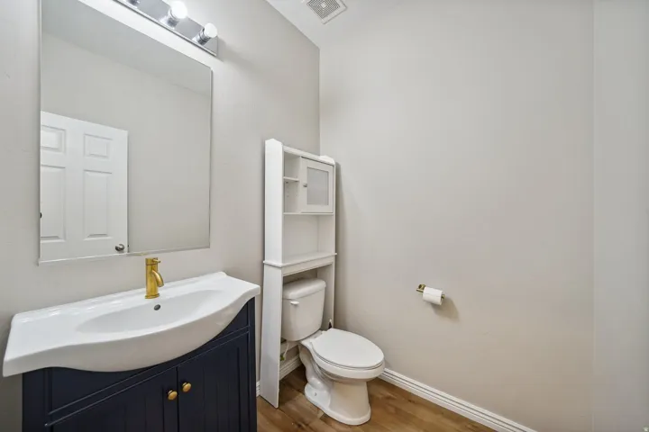 Navy blue vanity with gold hardware and a gold-finish faucet