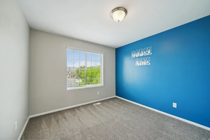 Carpeted room featuring a single window with blinds and a flush mount light fixture