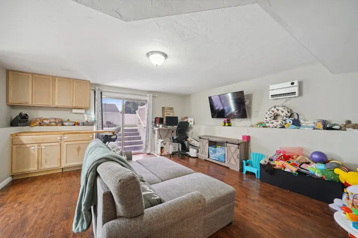 Wood-finish flooring, built-in cabinetry with a light wood finish, recessed lighting, and a sliding glass door