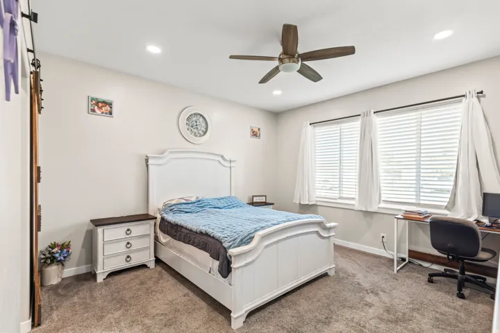 Recessed lighting, wood-finish ceiling fan, and two windows with blinds