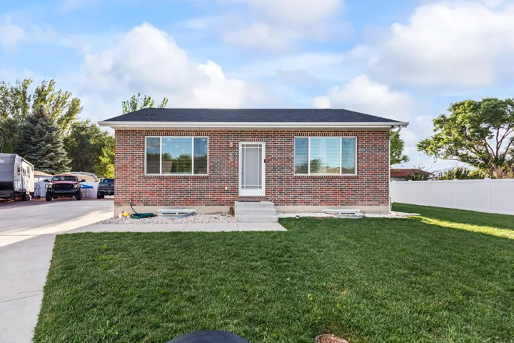 Brick exterior with a dark shingle roof, white trim, and a white storm door