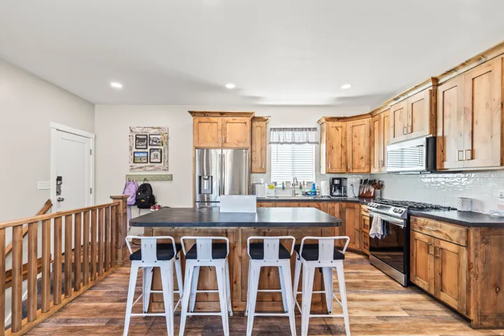 Kitchen featuring wood-finish flooring, wood cabinetry, a center island with countertop, and stainless steel appliances