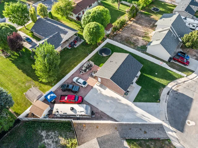 Expansive lot with a large paved driveway, a gravel parking area, and a lush green lawn