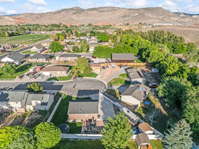 Residential neighborhood with varied rooflines and mature landscaping, set against a backdrop of distant mountains