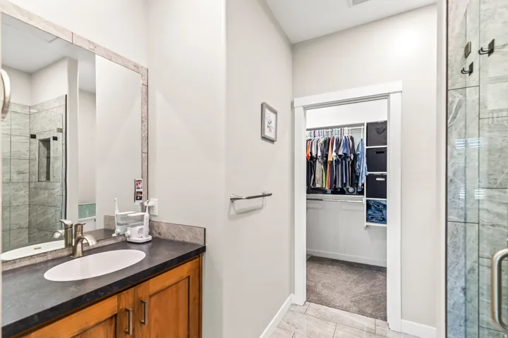 Wood-finish vanity with an undermount sink, dark countertop, and brushed nickel faucet