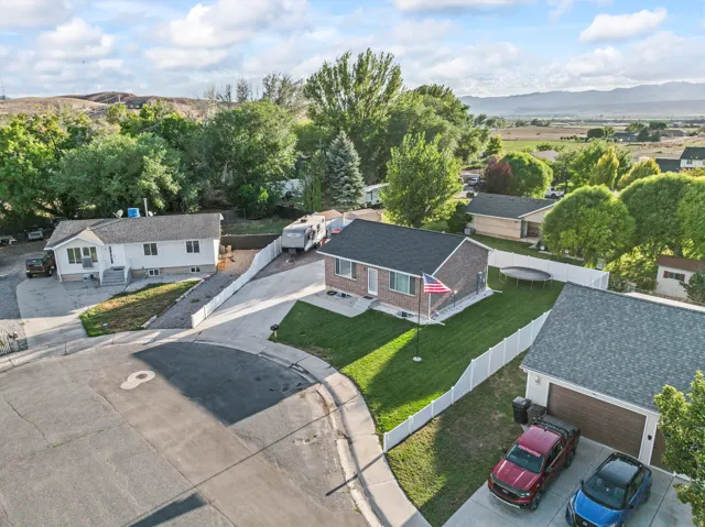 Property with a fenced yard, mature trees, and an attached garage