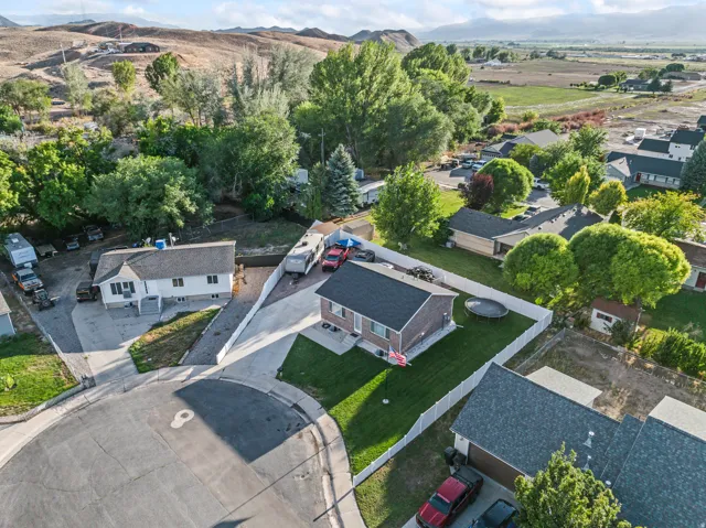 Aerial perspective showcasing the residential setting, mature trees, and nearby fields