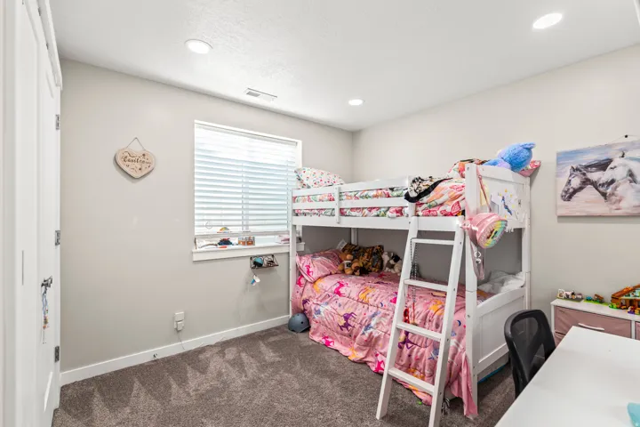 Recessed lighting, light gray wall paint, white trim, window with blinds, and dark carpet flooring