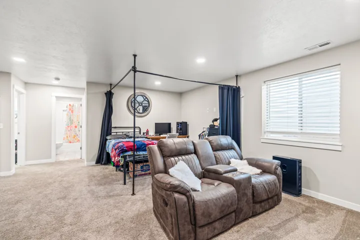 Carpeted flooring, recessed lighting, white window blinds, white trim, and a built-in privacy partition