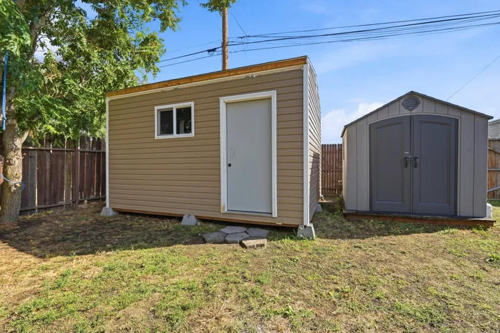 Two detached storage sheds with exterior siding and fencing