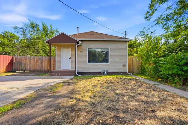 Siding exterior with a covered entry, concrete driveway, and a fenced perimeter