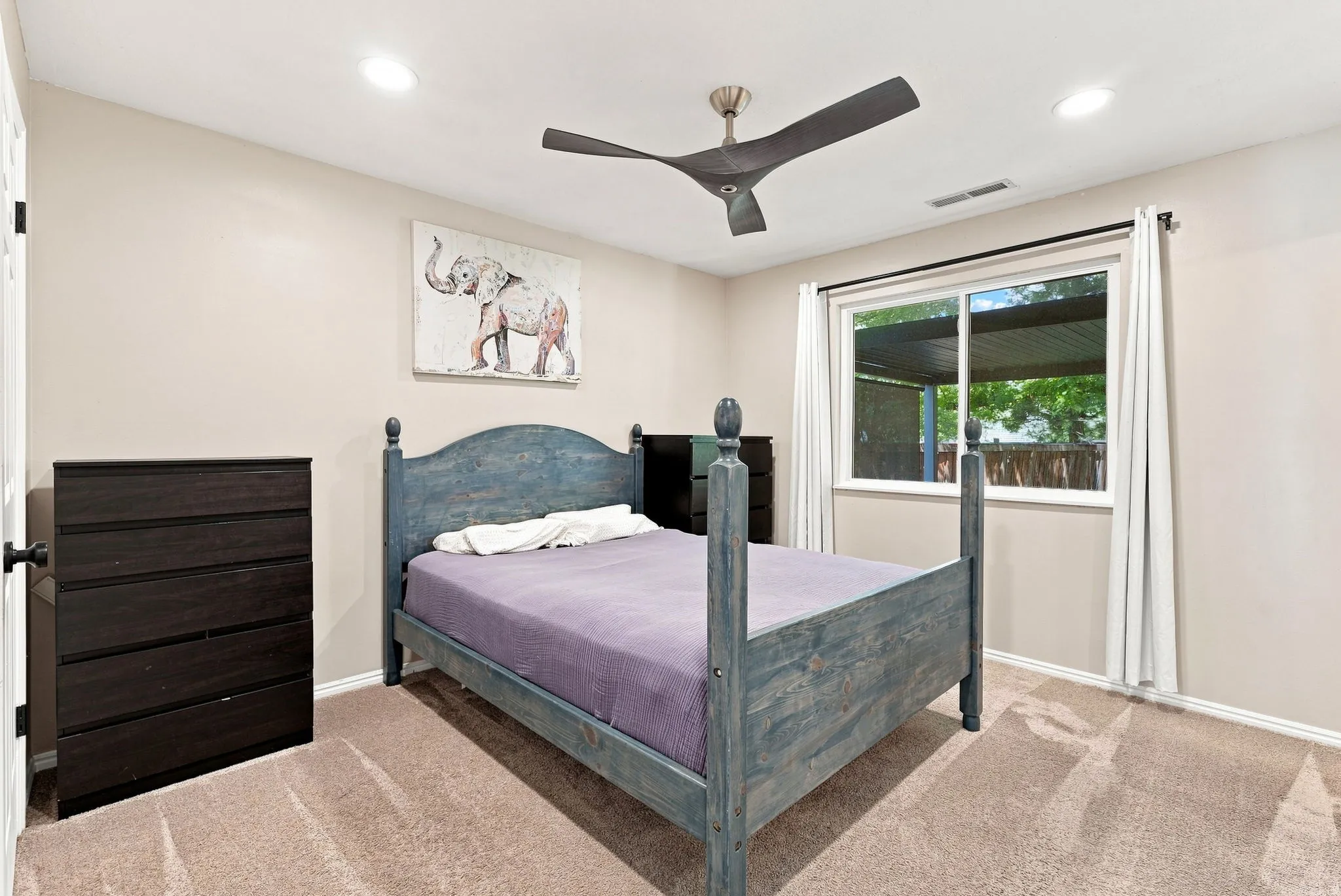 Recessed ceiling lighting, ceiling fan with three blades, light beige wall paint, single window with white trim, and light brown carpet flooring