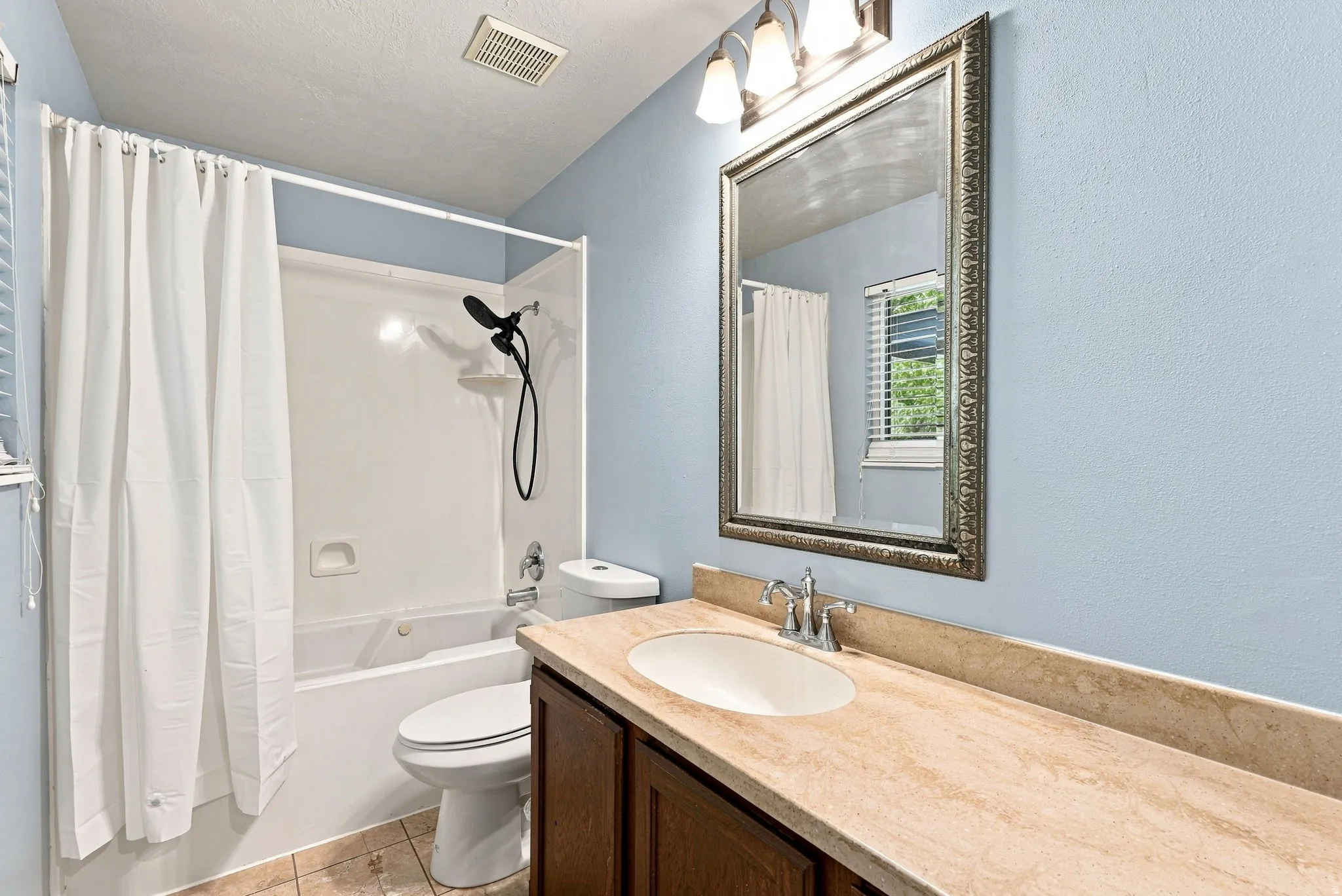 Tile flooring complementing a light-colored vanity with an integrated sink