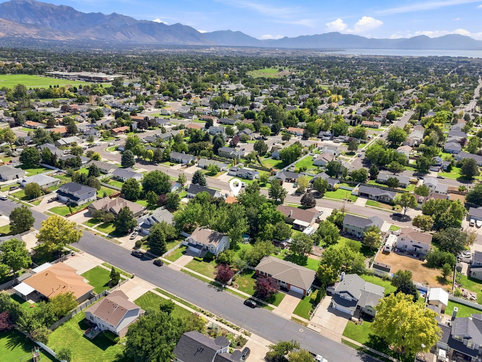 Expansive residential area with mature trees and mountain scenery