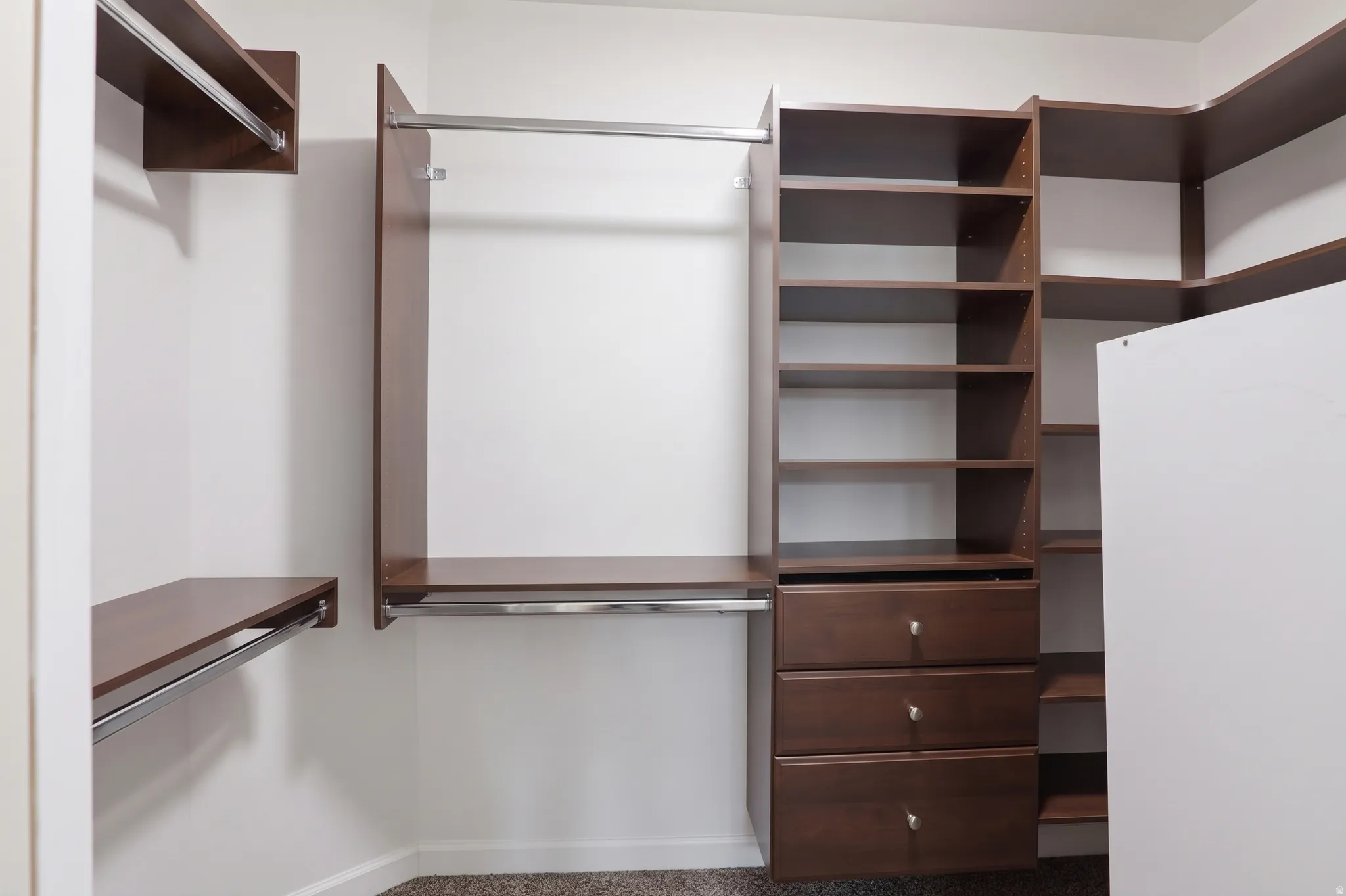 Custom closet system featuring shelving, hanging rods, and built-in drawers