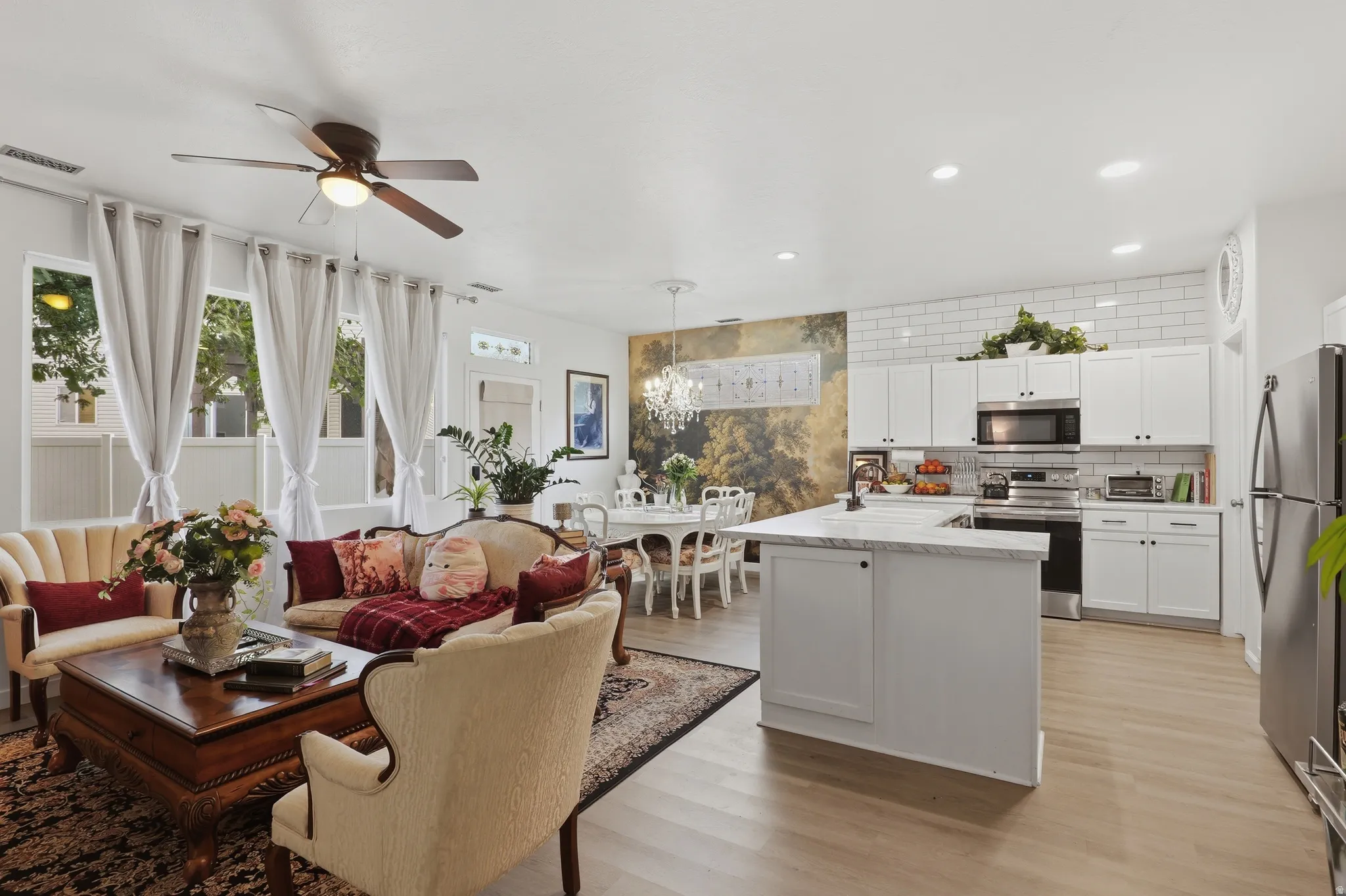 Open-concept living area with wood-finish flooring, recessed lighting, and a ceiling fan