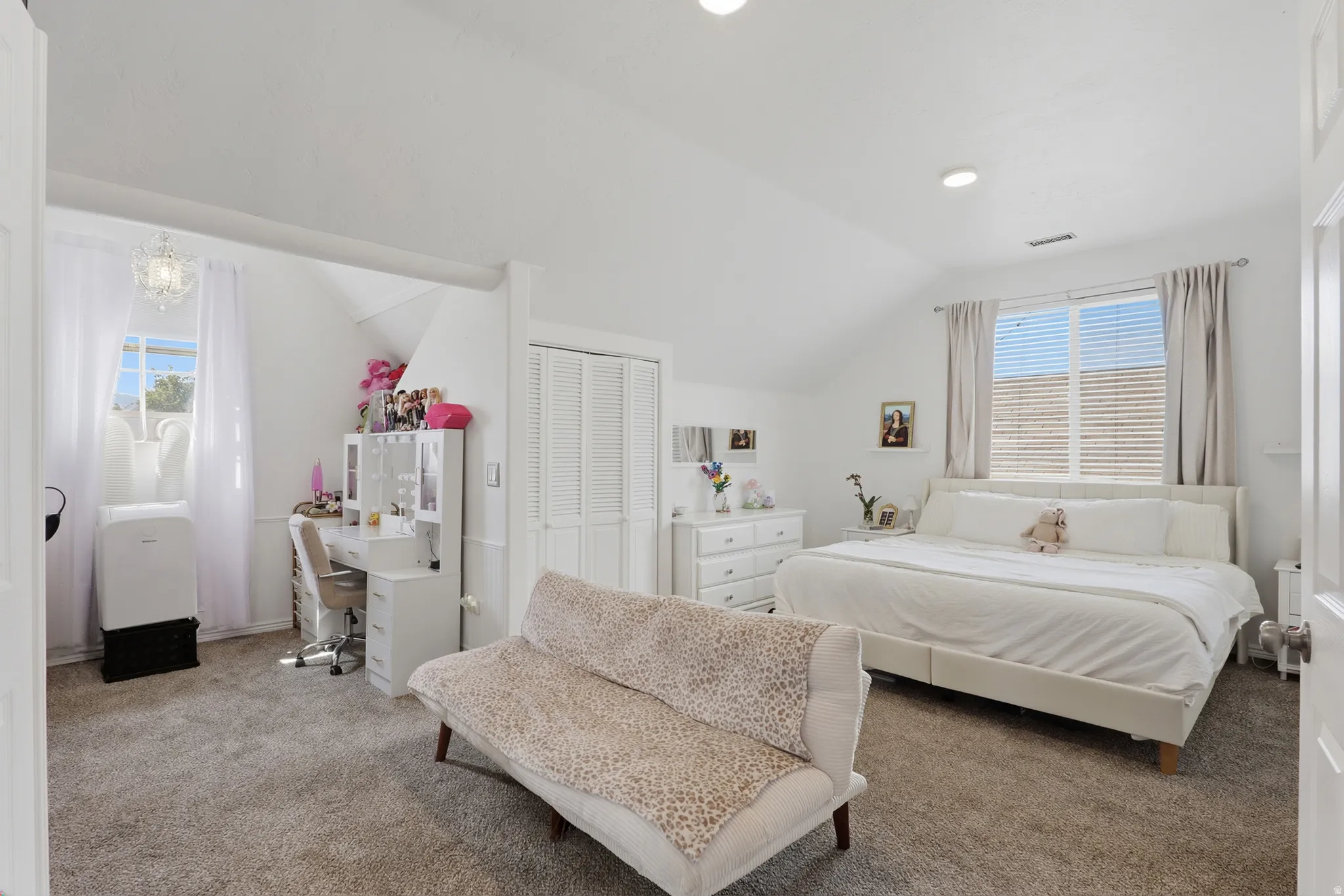 Carpeted flooring, vaulted ceiling, recessed lighting, window with blinds, and a built-in closet with louvered doors