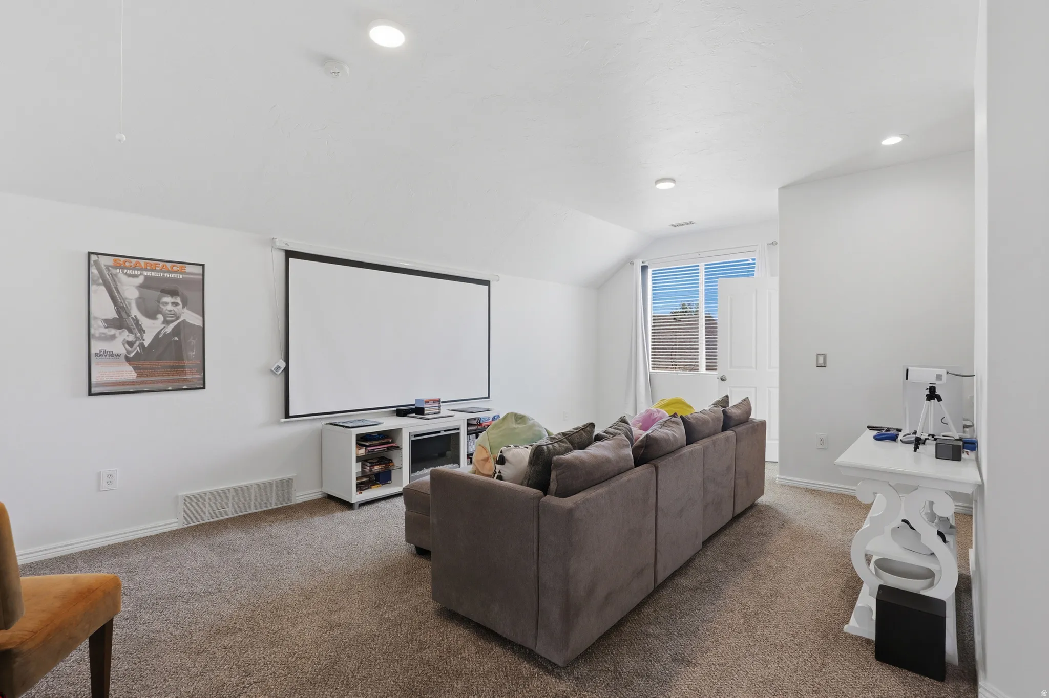 Carpeted room with a vaulted ceiling, recessed lighting, and an exterior door with multiple window panes