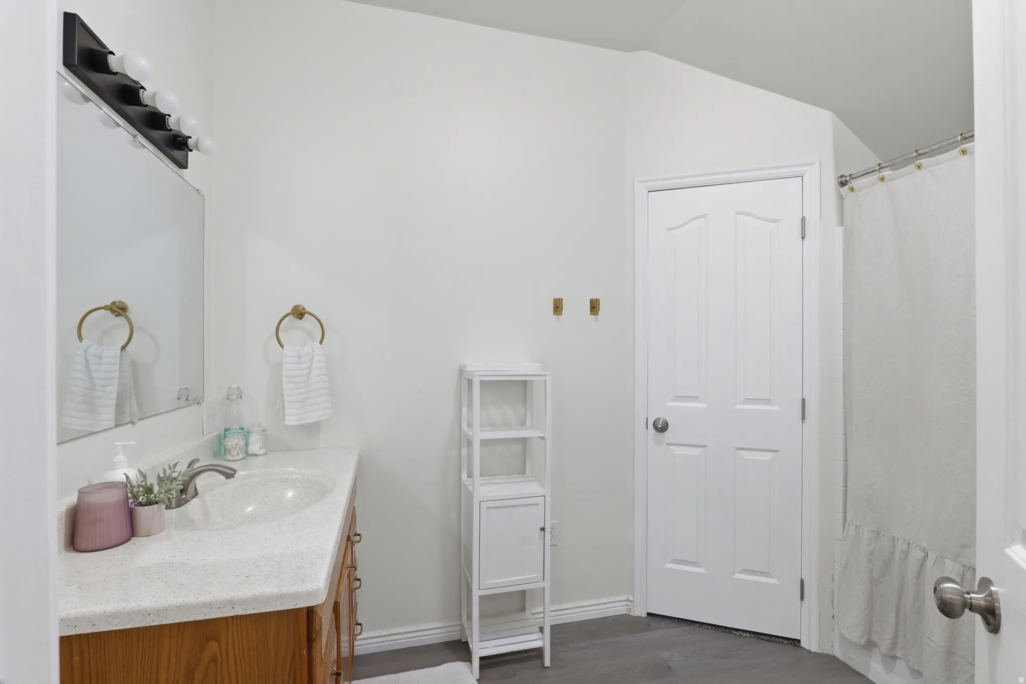 Vanity with a built-in sink, light wood-finish cabinetry, and a light-colored countertop
