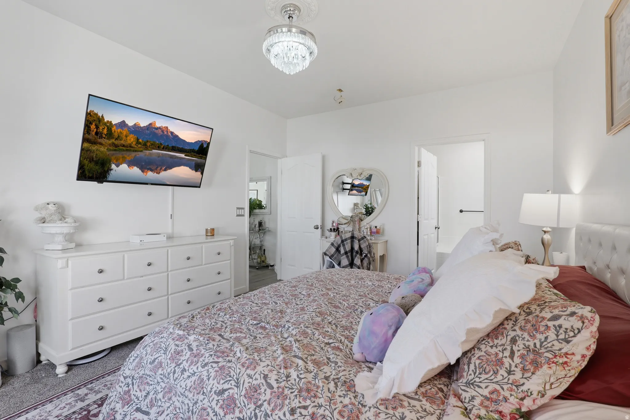 White walls with a crystal chandelier and recessed lighting