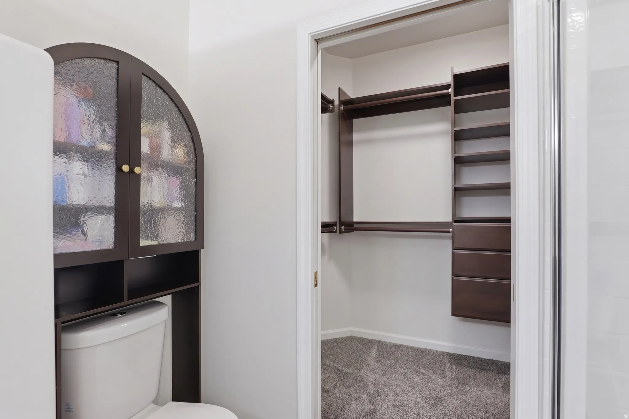 Custom closet system with multiple rods, shelving, and drawers