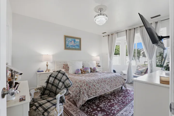 White walls with a crystal-style ceiling light fixture, framed windows, and a decorative area rug