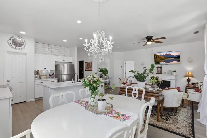 Open-concept living area featuring a decorative chandelier, recessed lighting, and wood-finish flooring