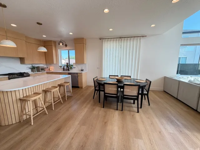Open concept living space featuring wood-finish flooring, recessed lighting, and a kitchen with light wood cabinetry